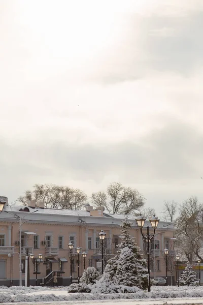 Ukrayna 'nın güneyindeki güzel İzmail kasabası, kış manzarası binalar, ağaçlar, sokak lambaları karla kaplı ve bulutlu gökyüzü