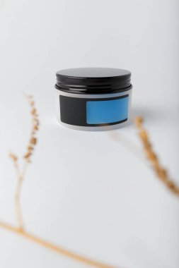 Boş mavi etiketli krema kutusu, beyaz arkaplanda şablon oluşturun. Yüz ve vücut bakımı, beton dekorlu kozmetik ürünleri, kopyalama alanı