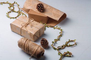 Noel hediyesi ambalajı, çevre dostu dekor, çam kozalakları, jüt ip ve ambalaj kağıdı. Doğal, ekolojik olarak temiz malzemeler.