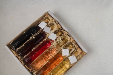 Tahta talaş kutusunda 250 ml kırmızı, pembe, beyaz şarap var. Etiketi yok. Hediye ya da kutlama için içki seti