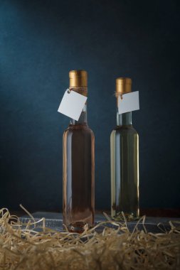 İki adet 250 ml beyaz ve pembe şarap seti ve boş etiketler. Aşağıdaki ahşap talaşları. Şarap çeşitleri. Uzayı kopyala, dikey çekim