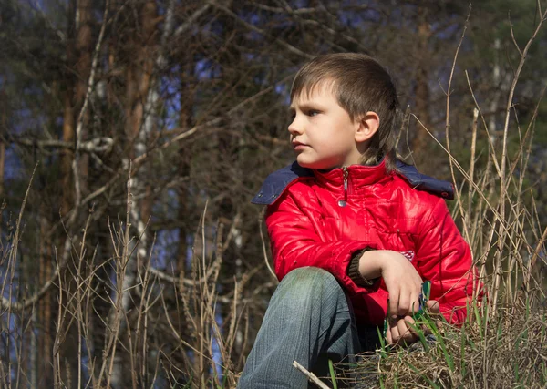 Jongen in jas op zoek in de verte — Stockfoto