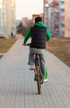 Bisiklet süren genç adam.