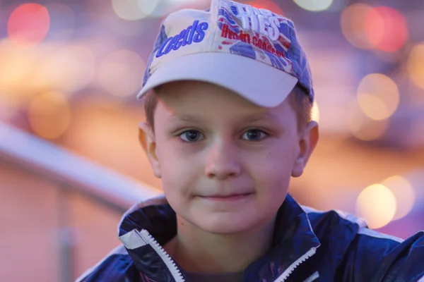 Boy on a background of evening city lights — Stock Photo, Image