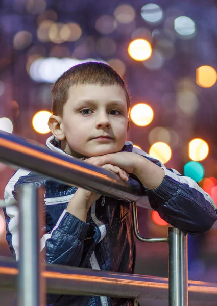 Boy on a background of evening city lights — Stock Photo, Image