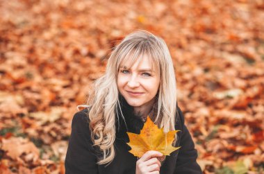 Gülümseyen güzel sonbahar kadınının açık havada portresi