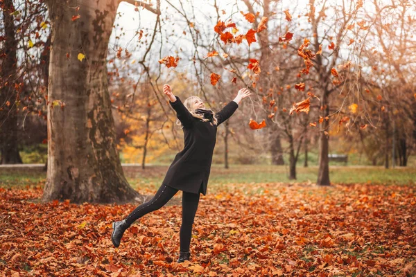 とても幸せと笑顔の女の子は楽しい秋の公園にあります — ストック写真