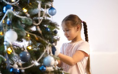 küçük kız evde oyuncaklar ile Noel ağacı süsleme