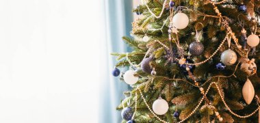 Yeni yılın mavi ve beyaz oyuncakları bir Noel ağacında asılı. Noel ağacı süslemesi. Yeni yıl ve Noel. Uzayı kopyala Pankart