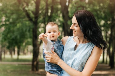 Mutlu anne ve bebek yaz günü kameraya bakıyor.