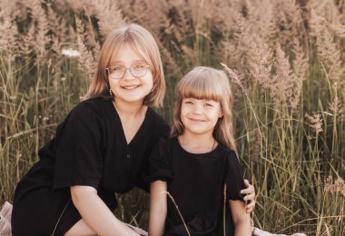 Güneşli bir günde parkta iki kız kardeş. Aile zamanı