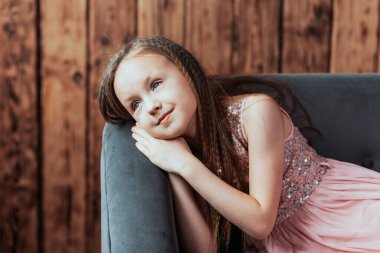 Gülümseyen kız evdeki kameraya bakarak düşünüyor.