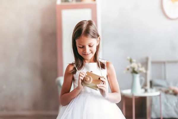 Menina Vestido Branco Segurando Uma Câmera Brinquedo — Fotografia de Stock