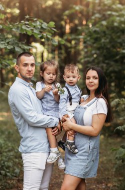 Genç ve mutlu bir aile dışarıda eğleniyor. Anne, baba ve küçük oğlu dışarıda dinleniyor. Beraberlik, aşk, mutluluk konsepti.