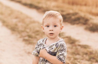 Küçük çocuk yazın doğada oynar ve yürür. Mutlu bir çocukluk. Pozitif duygular