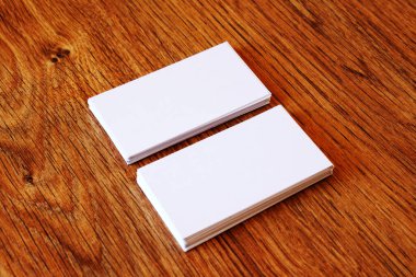 Ahşap yüzey üzerindeki beyaz kartvizitler model için idealdir.