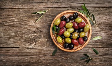 Ahşap masada yeşil, siyah ve kırmızı zeytinyağı. Üst görünüm