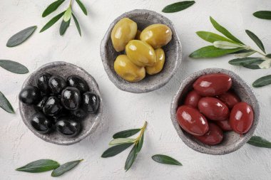 Taş masada yeşil, siyah ve kırmızı zeytinyağı. Üst görünüm