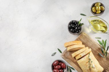 Bakire zeytin yağı, zeytin ve masada taze ekmek. Üst görünüm