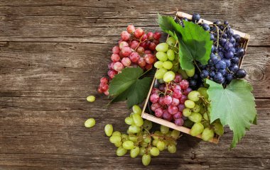 Ahşap arka planda, tahta kutuda üzüm. Üst görünüm