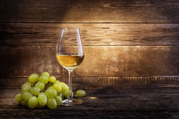 Ahşap arka planda üzüm ve beyaz şarap. Boşluğu kopyala