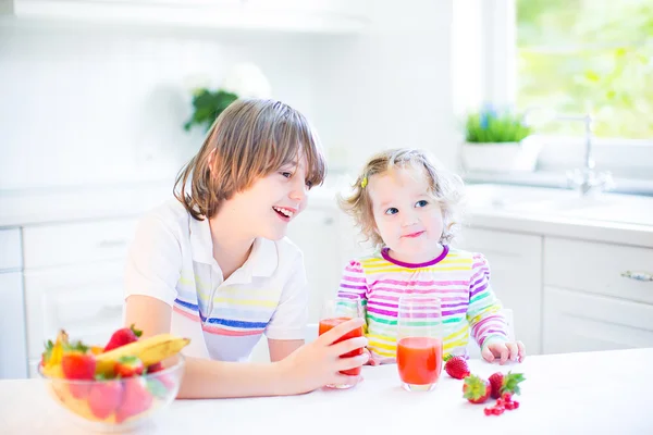 Niño y hermana tomando frutas y cereales con fresa para el desayuno —  Fotos de Stock