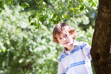 büyük bir ağaç altında oynayan çocuk