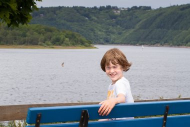 bir bankta oturan çocuk