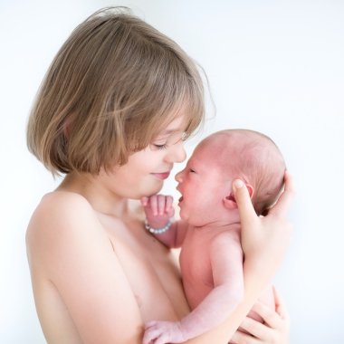 Yeni doğan bebek kardeşi ile oynayan genç çocuk