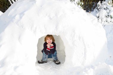 bir kar Igloo güneşli kış gününde oynayan çocuk
