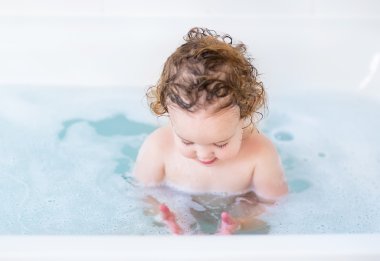 Bebek güzel mavi gözleri ve kıvırcık saç alarak banyo