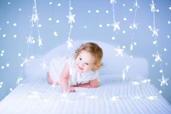 Adorável menina criança jogando em uma cama — Fotografia de Stock