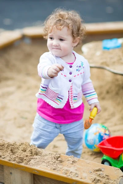 Baby flicka gräva i sanden — Stockfoto