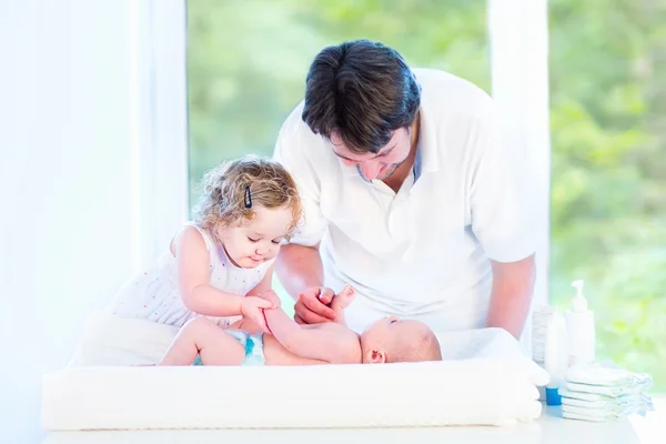 Newborn baby looking at his father and toddler sister — Stock Photo, Image