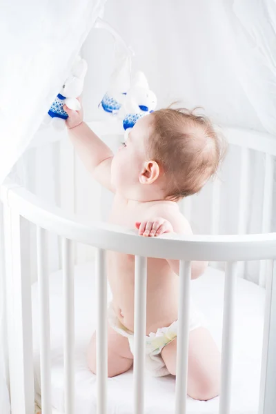 Engraçado bebê brincando em seu berço — Fotografia de Stock