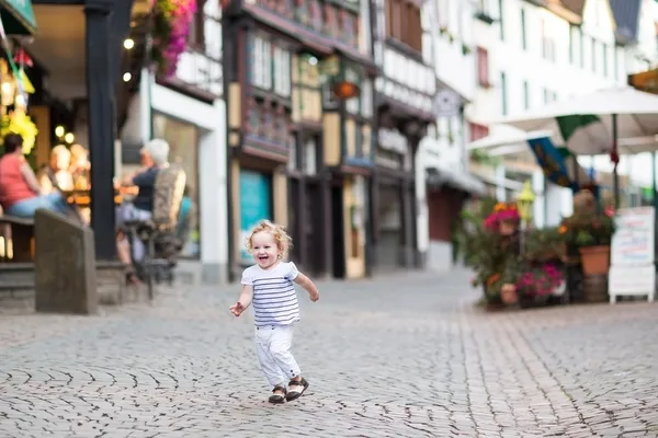 Маленькая девочка бежит по красивой улице — стоковое фото