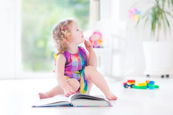 Fille aux cheveux bouclés blonds lisant un livre — Photo