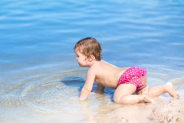 Baby playing in the water on a beach — Stock Photo, Image