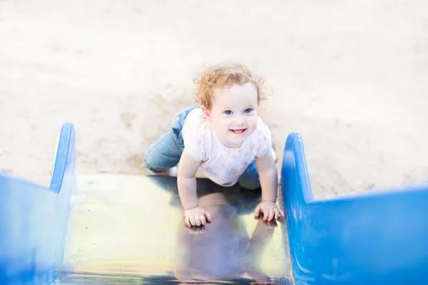 Menina jogando em um slide — Fotografia de Stock
