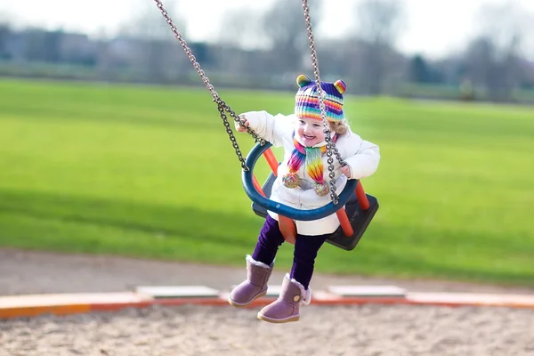 Menina criança balançando em um playground — Fotografia de Stock