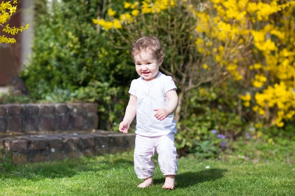 Adorable baby girl playing in a garden — Stock Photo, Image