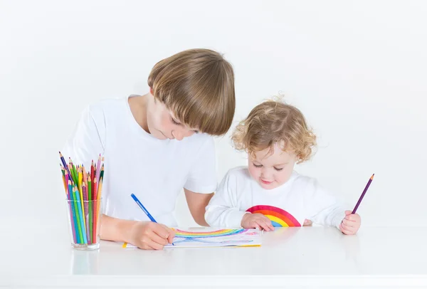 Toddler dziewczynka rysunek z kolorowe kredki i jej brat — Zdjęcie stockowe
