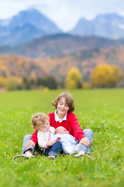 Three kids playing in beautiful snow covered mountains — Stock Photo, Image