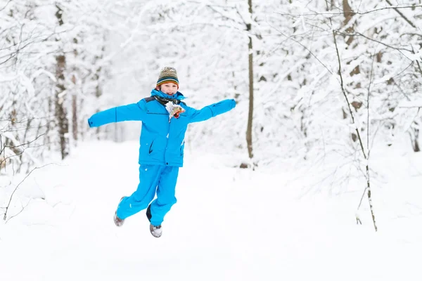 Pojke leker med snö i en winter park — Stockfoto