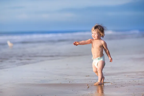 Baby flicka kör på en vacker tropisk strand — Stockfoto