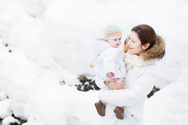 Moeder en baby in een besneeuwde park — Stockfoto