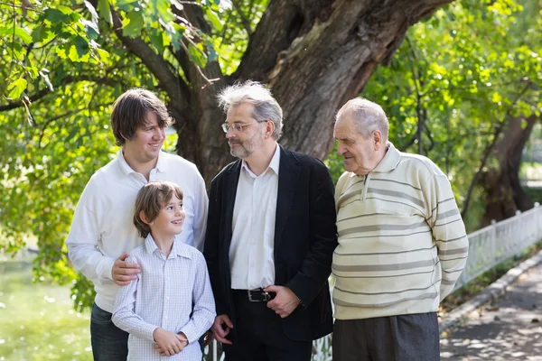 Quatre générations d'hommes debout dans un parc — Photo