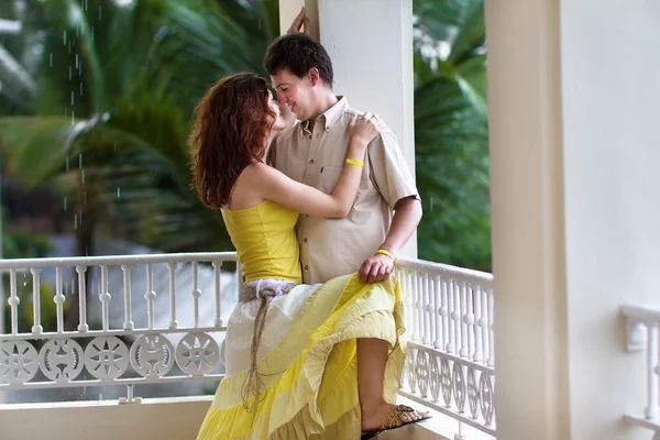 Casal em uma varanda em uma chuva tropical — Fotografia de Stock