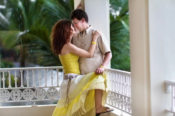 Couple on a balcony in a tropical rain — Stock Photo, Image