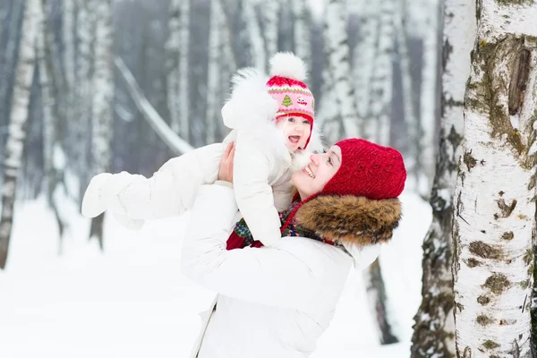 Moeder en baby in een besneeuwde park — Stockfoto